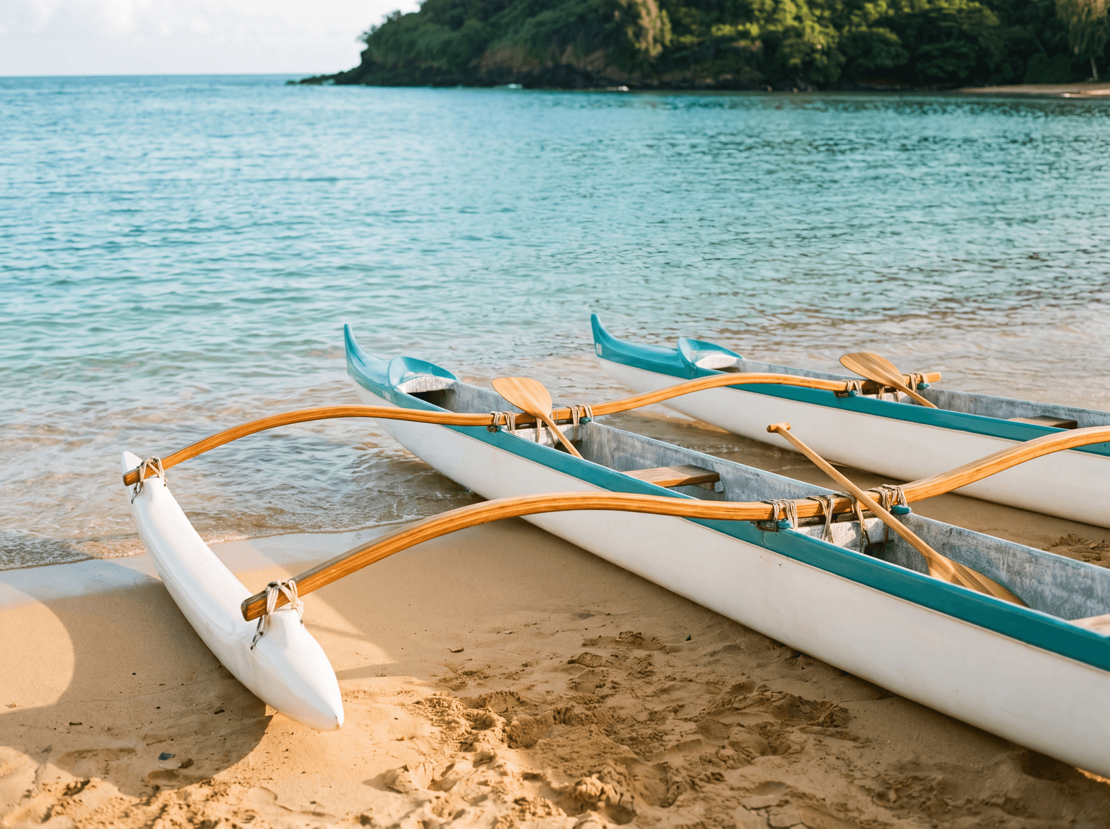 Outrigger canoes on the sand on a calm morning