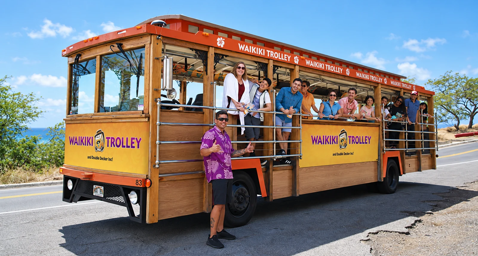 Visitors and a welcoming driver beside an open-air wooden trolley